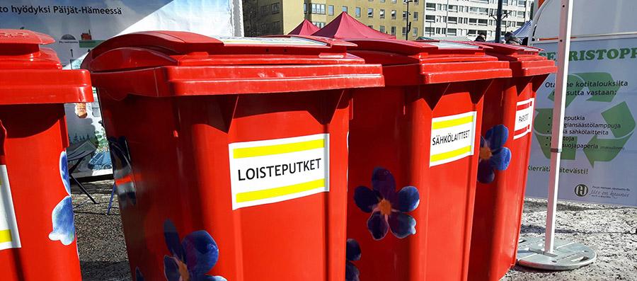 Kuvassa punaisia serristoppi vastaanottopisteen jäteastioita kuvattuna Lahden kauppatorilla.
