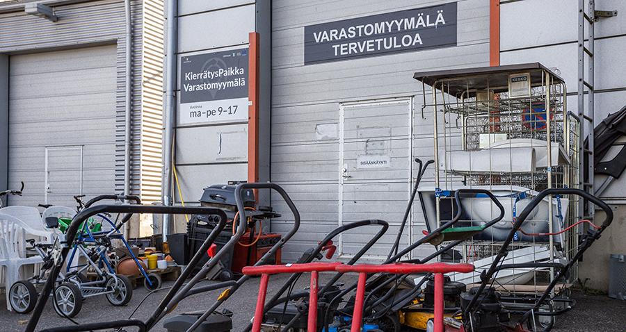 Kuvassa Kujalan KierrätysPaikka-varastomyymälän sisäänkäynti Kujalan jätekeskuksessa, oven edustalla kierrätystavaraa.